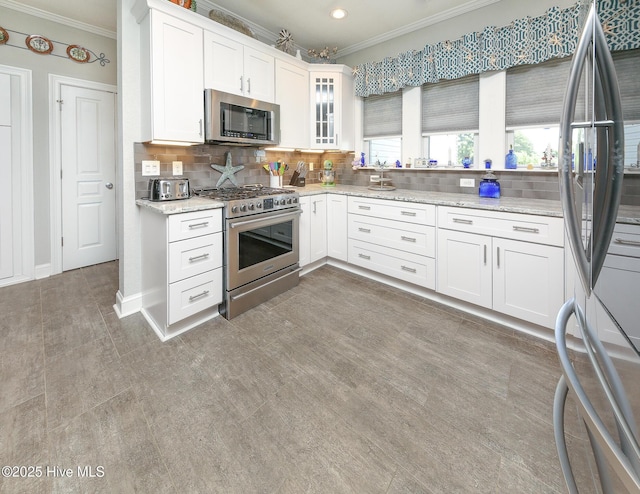 104 Soundside Estates Dr, Grandy, NC 27939 - kitchen featuring stainless steel appliances, crown molding, tasteful backsplash, white cabinets, and glass insert cabinets