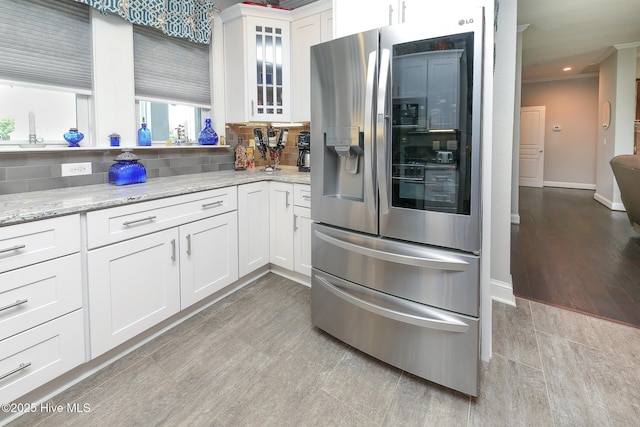104 Soundside Estates Dr, Grandy, NC 27939 - kitchen with stainless steel fridge with ice dispenser, glass insert cabinets, light stone countertops, white cabinets, and decorative backsplash
