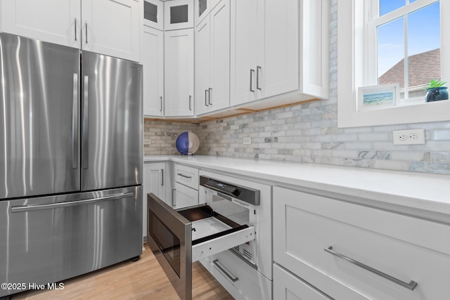 2705 E Oak Island Dr, Oak Island, NC 28465 - kitchen with freestanding refrigerator, tasteful backsplash, and white cabinets