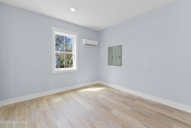 2705 E Oak Island Dr, Oak Island, NC 28465 - spare room with a wall mounted AC, wood finished floors, electric panel, and baseboards