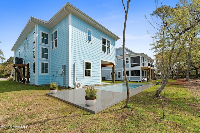 2705 E Oak Island Dr, Oak Island, NC 28465 - back of house featuring a sunroom, cooling unit, a yard, a patio, and a cooling unit