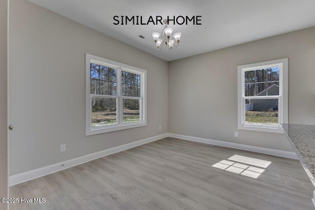 98 NE Dr NW, Calabash, NC 28467 - spare room with a chandelier, plenty of natural light, wood finished floors, and baseboards