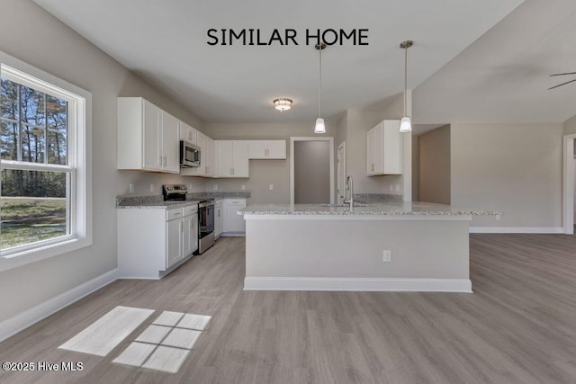 98 NE Dr NW, Calabash, NC 28467 - kitchen with stainless steel appliances, light stone countertops, baseboards, light wood-style flooring, and a sink