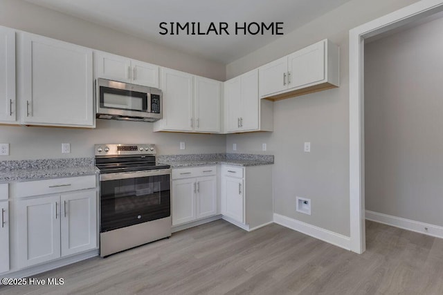 98 NE Dr NW, Calabash, NC 28467 - kitchen with stainless steel appliances, light wood-style floors, white cabinetry, light stone countertops, and baseboards