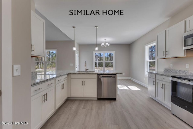 98 NE Dr NW, Calabash, NC 28467 - kitchen with appliances with stainless steel finishes, a sink, light wood-style floors, and white cabinets