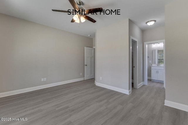 98 NE Dr NW, Calabash, NC 28467 - unfurnished bedroom featuring wood finished floors, baseboards, ensuite bathroom, and a ceiling fan