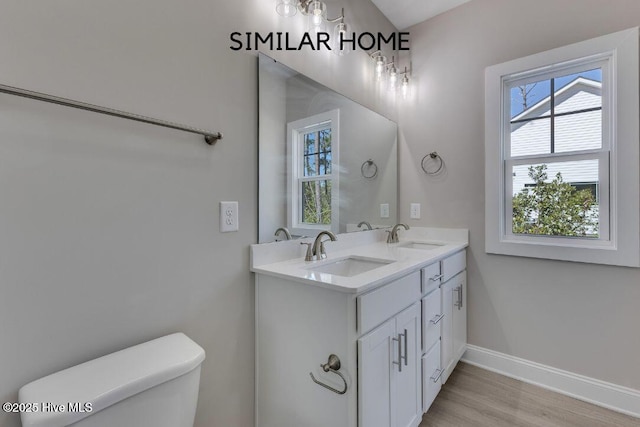 98 NE Dr NW, Calabash, NC 28467 - bathroom featuring healthy amount of natural light, double vanity, toilet, and wood finished floors