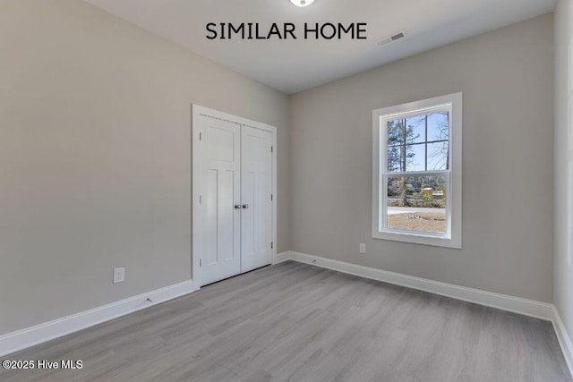 98 NE Dr NW, Calabash, NC 28467 - unfurnished bedroom with wood finished floors, baseboards, and a closet