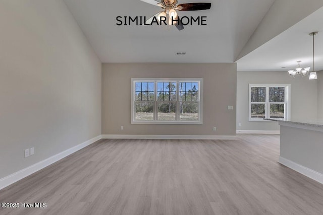 98 NE Dr NW, Calabash, NC 28467 - unfurnished living room with vaulted ceiling, plenty of natural light, a chandelier, wood finished floors, and a ceiling fan