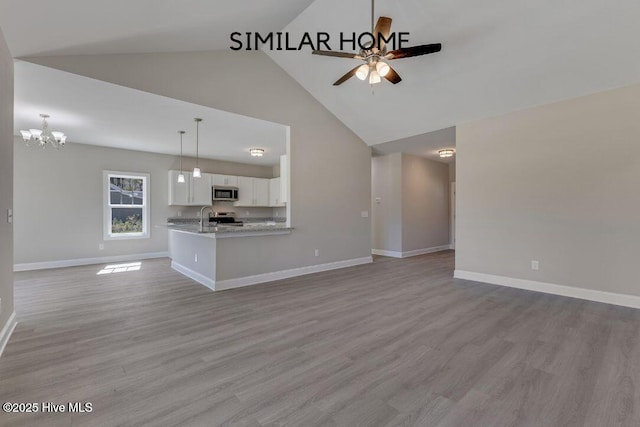 98 NE Dr NW, Calabash, NC 28467 - unfurnished living room featuring a ceiling fan, high vaulted ceiling, baseboards, wood finished floors, and a sink