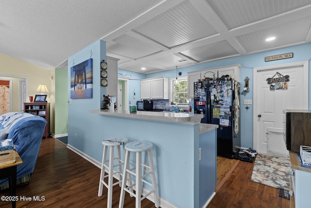 107 Foxlair Dr, Hubert, NC 28539 - kitchen featuring freestanding refrigerator, dark wood finished floors, a kitchen bar, light countertops, and coffered ceiling
