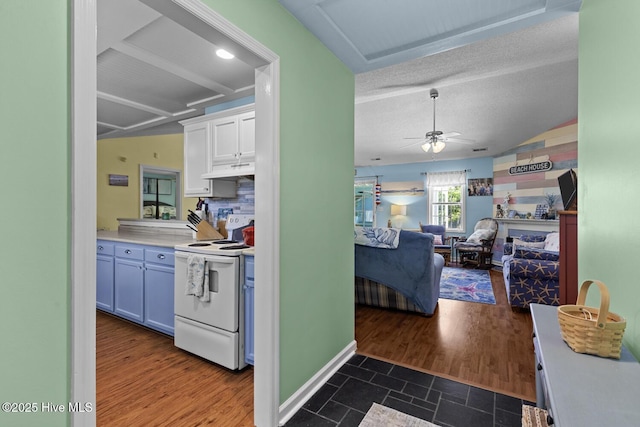 107 Foxlair Dr, Hubert, NC 28539 - kitchen with electric range, under cabinet range hood, white cabinetry, ceiling fan, and light countertops