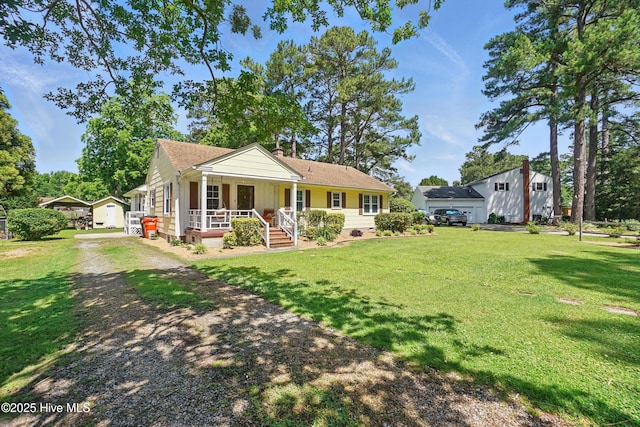 1605 Edgewood Dr, Elizabeth City, NC 27909 - view of front of house featuring a porch, a front lawn, a chimney, and dirt driveway
