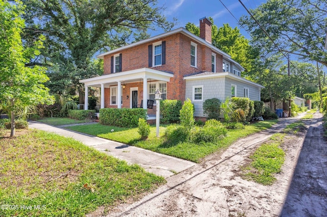 114 N 16th St, Wilmington, NC 28401 - view of front of property with covered porch, a chimney, brick siding, and a front yard