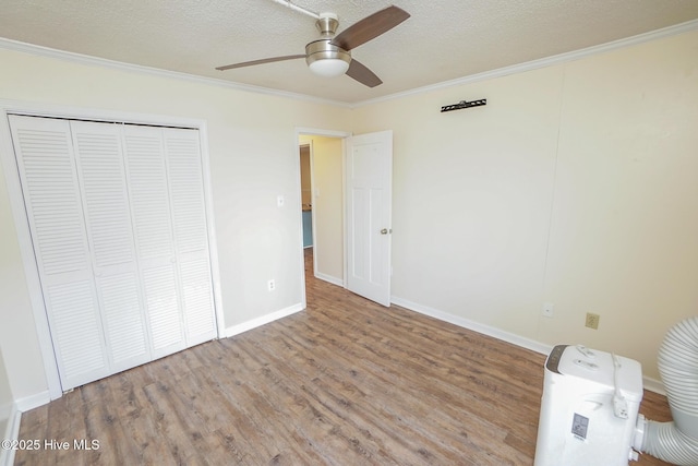 2264 New River Inlet Rd Unit 210, North Topsail Beach, NC 28460 - unfurnished bedroom with ornamental molding, wood finished floors, a closet, baseboards, and a ceiling fan