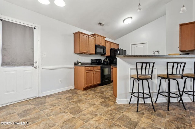 213 Lockwood Ct, Hubert, NC 28539 - kitchen featuring black appliances, a kitchen breakfast bar, dark countertops, baseboards, and vaulted ceiling