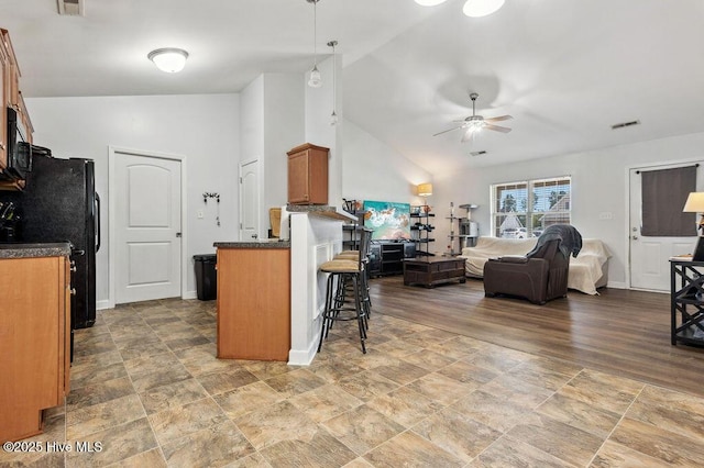 213 Lockwood Ct, Hubert, NC 28539 - kitchen featuring a ceiling fan, dark countertops, a kitchen breakfast bar, brown cabinetry, and open floor plan