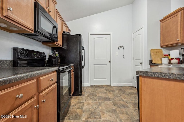213 Lockwood Ct, Hubert, NC 28539 - kitchen featuring black appliances, dark countertops, brown cabinetry, vaulted ceiling, and baseboards