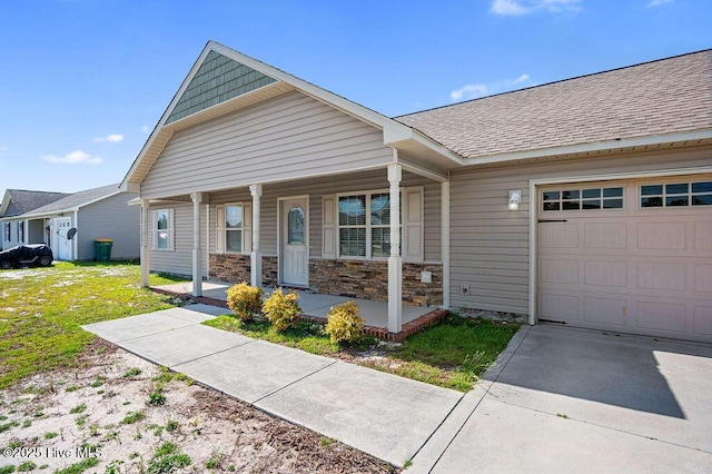 213 Lockwood Ct, Hubert, NC 28539 - view of front of house featuring covered porch, an attached garage, a shingled roof, stone siding, and a front lawn