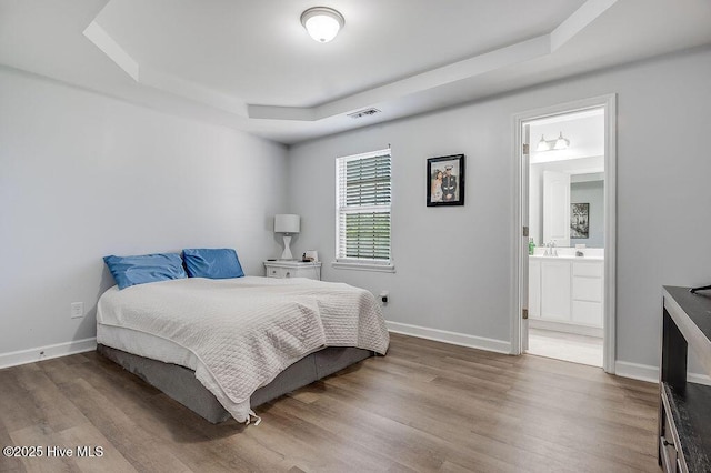 213 Lockwood Ct, Hubert, NC 28539 - bedroom featuring a raised ceiling, wood finished floors, baseboards, and ensuite bathroom