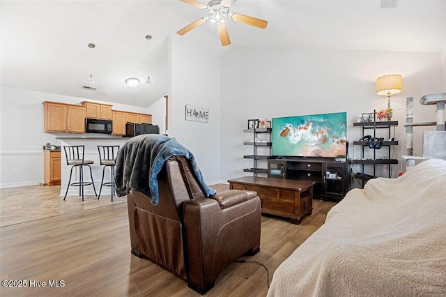 213 Lockwood Ct, Hubert, NC 28539 - living room featuring a ceiling fan, high vaulted ceiling, baseboards, and light wood-style flooring