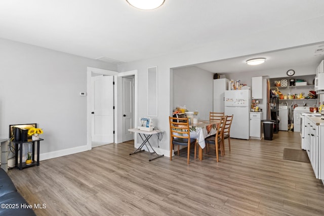 406 Walnut St, Elizabeth City, NC 27909 - dining room with light wood-style flooring, baseboards, and washer and dryer