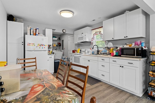 406 Walnut St, Elizabeth City, NC 27909 - kitchen featuring white appliances, a sink, light wood-type flooring, white cabinets, and light countertops