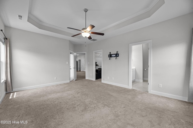 2001 Snapper St, New Bern, NC 28562 - unfurnished bedroom featuring a tray ceiling, light colored carpet, crown molding, ensuite bath, and a spacious closet