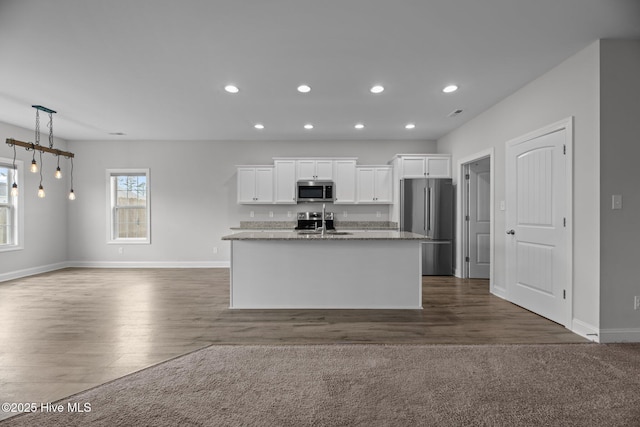 2001 Snapper St, New Bern, NC 28562 - kitchen with appliances with stainless steel finishes, white cabinets, dark wood finished floors, an island with sink, and recessed lighting