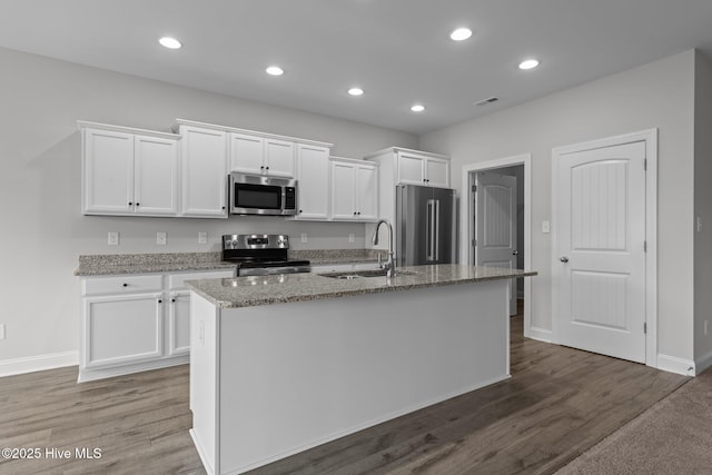2001 Snapper St, New Bern, NC 28562 - kitchen with appliances with stainless steel finishes, a sink, white cabinets, a center island with sink, and wood finished floors