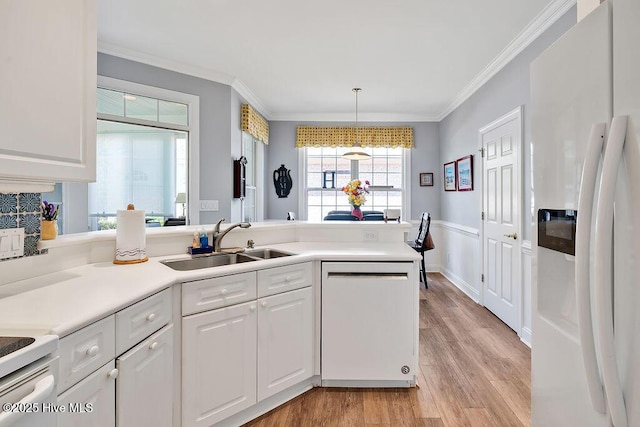 3212 Wexford Way, Southport, NC 28461 - kitchen featuring white appliances, ornamental molding, light wood finished floors, white cabinetry, and a peninsula