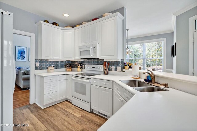 3212 Wexford Way, Southport, NC 28461 - kitchen featuring white appliances, ornamental molding, light wood-type flooring, decorative backsplash, and white cabinets