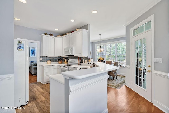 3212 Wexford Way, Southport, NC 28461 - kitchen with white appliances, light wood-style flooring, a peninsula, white cabinetry, and recessed lighting