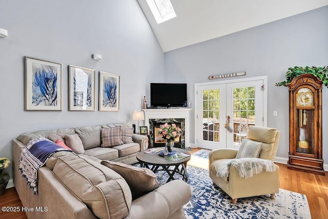 3212 Wexford Way, Southport, NC 28461 - living room featuring high vaulted ceiling, a skylight, wood finished floors, french doors, and a high end fireplace