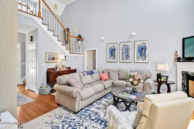 3212 Wexford Way, Southport, NC 28461 - living area featuring a high ceiling, wood finished floors, stairs, and a premium fireplace