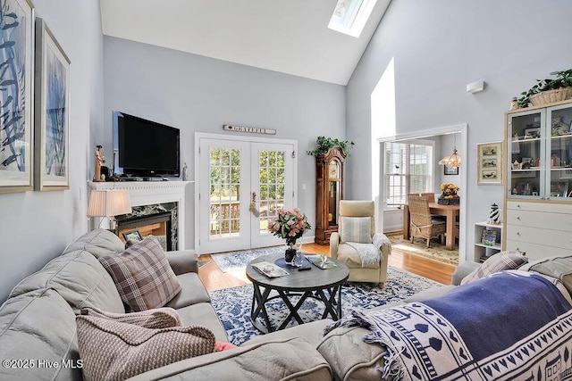 3212 Wexford Way, Southport, NC 28461 - living room with high vaulted ceiling, wood finished floors, healthy amount of natural light, a skylight, and french doors
