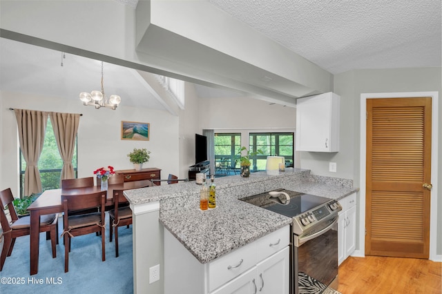 728 Azalea Dr Unit 426, Hampstead, NC 28443 - kitchen featuring stainless steel electric stove, a peninsula, white cabinets, a chandelier, and light stone countertops