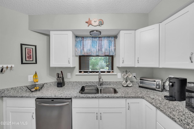 728 Azalea Dr Unit 426, Hampstead, NC 28443 - kitchen featuring dishwasher, a sink, white cabinets, a textured ceiling, and light stone counters