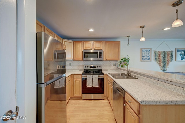 909 Carolina Beach Ave N Unit 2B, Carolina Beach, NC 28428 - kitchen with stainless steel appliances, a sink, light wood-style floors, a peninsula, and light countertops