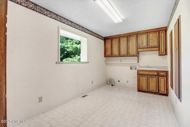 102 Trollingwood Dr, Goldsboro, NC 27534 - washroom with hookup for an electric dryer, light flooring, cabinet space, a textured ceiling, and hookup for a washing machine