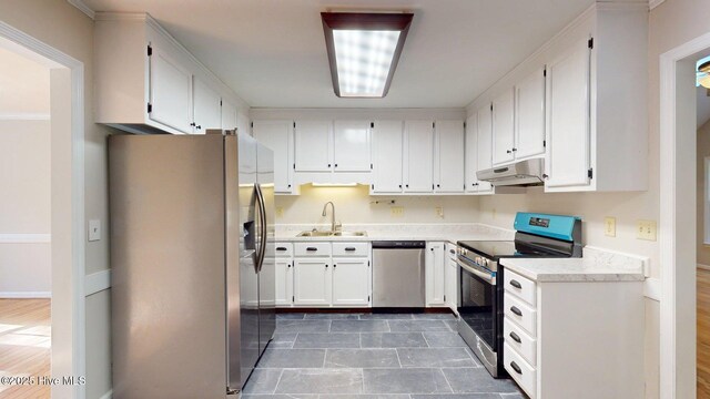 165 Sandhurst Pl, Southern Pines, NC 28387 - kitchen featuring appliances with stainless steel finishes, a sink, under cabinet range hood, light countertops, and white cabinetry