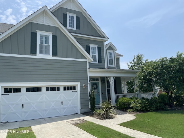 8395 Penny Royal Ln, Wilmington, NC 28412 - view of front facade with board and batten siding, covered porch, an attached garage, and a front yard