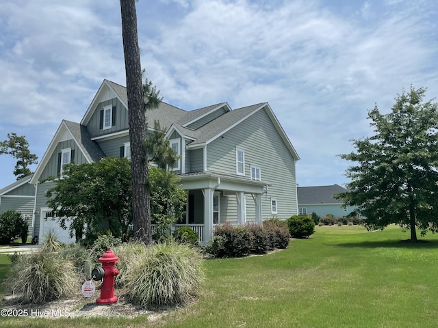 8395 Penny Royal Ln, Wilmington, NC 28412 - view of side of home with board and batten siding, a lawn, covered porch, and a shingled roof