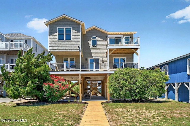1116 E Beach Dr, Oak Island, NC 28465 - back of house with stairs, a lawn, and a balcony