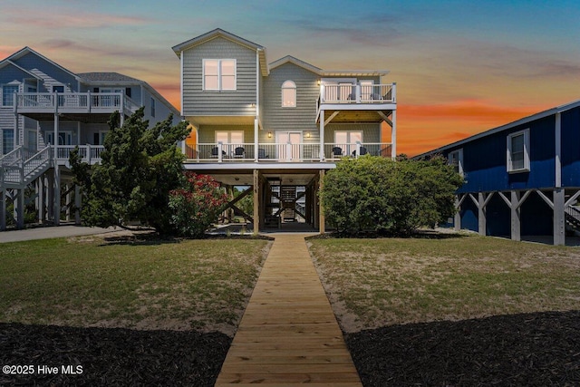1116 E Beach Dr, Oak Island, NC 28465 - back of property at dusk featuring stairway and a yard