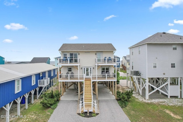 1116 E Beach Dr, Oak Island, NC 28465 - view of front facade featuring a carport, a balcony, and driveway