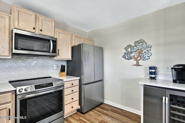 1116 E Beach Dr, Oak Island, NC 28465 - kitchen with stainless steel appliances, light brown cabinets, wine cooler, tasteful backsplash, and wood finished floors