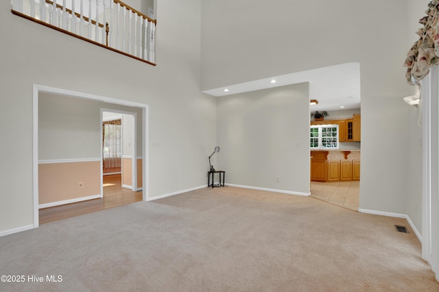 109 Country Club Dr, Rockingham, NC 28379 - unfurnished living room featuring light carpet, a towering ceiling, baseboards, and recessed lighting