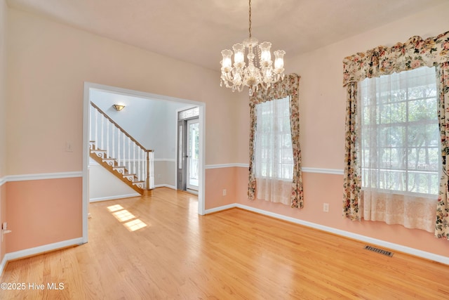 109 Country Club Dr, Rockingham, NC 28379 - spare room featuring wood finished floors, a chandelier, plenty of natural light, and stairs