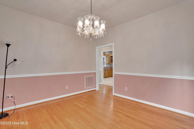 109 Country Club Dr, Rockingham, NC 28379 - unfurnished room featuring wood finished floors, baseboards, and a chandelier